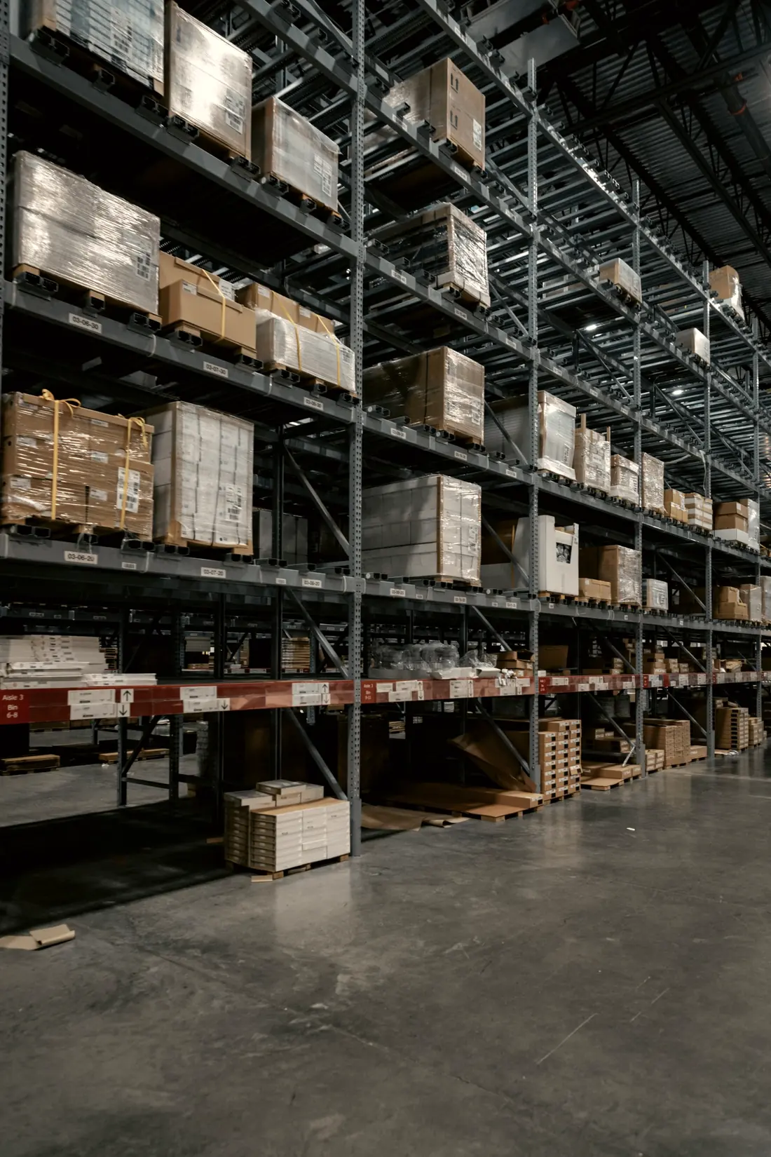 Bodega con estanterías y estibas de materiales embalados